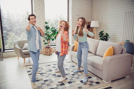 Funny young people friends enjoying time together in a cozy home interior with stylish furniture during daylightの写真素材