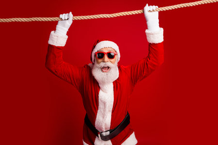 Santa in red sunglass cheerfully holding a rope, symbolizing festive spirit, on a vibrant red...