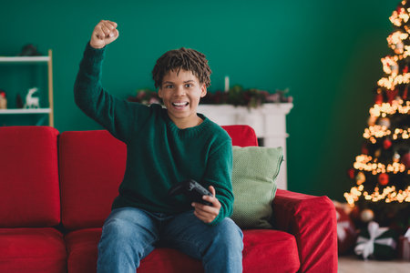 Excited teen on sofa celebrating holiday season with festive Christmas decor and cozy interior