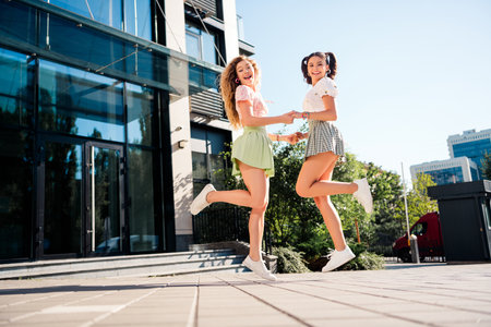 Funny upbeat city friends jump in the sunshine showcasing style friendship and carefree travel vibes...