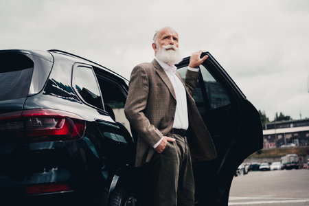 Confident Senior Businessman Exiting Luxury Car in Urban Setting Emphasizing Elegance and...