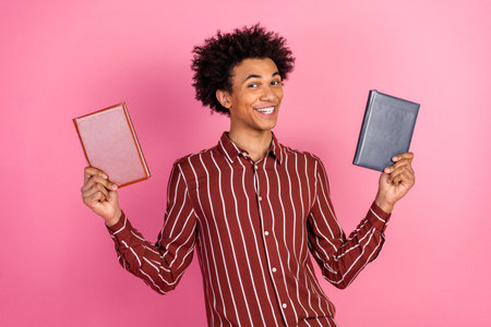 Smiling young man holding book against a colorful backdrop, expressing confidence and positivity
