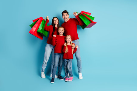 Happy family posing with colorful shopping bags in a festive winter atmosphere, celebrating the...