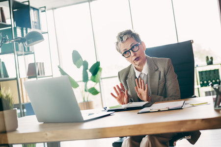 Confident businesswoman discussing strategy in modern office setting.