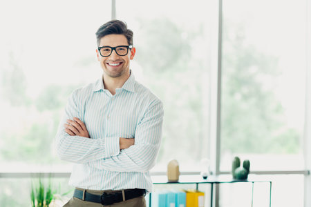 Confident young businessman in trendy office setting exuding professionalism and success wearing stylish attire.の写真素材