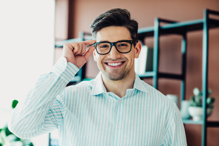 Confident young professional in office, dressed elegantly, wearing glasses, represents business leadership and successの写真素材