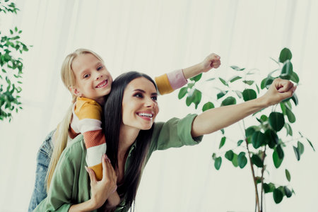 Mother and daughter bonding at home, enjoying playful moments in a cozy living room filled with love and happinessの写真素材