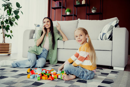Mother and daughter bonding in a cozy living room environment during a playful moment togetherの写真素材