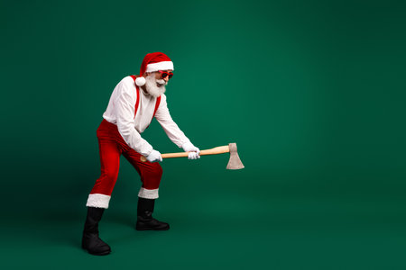 Santa Claus holding an ax in a humorous pose on a green background ready for holiday festivitiesの写真素材