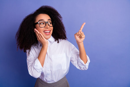 Young woman in business attire gestures excitedly with a creative idea against a vibrant backgroundの写真素材