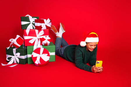 Youthful festive joy with holiday gifts, red themed accessories, and Santa hatの写真素材