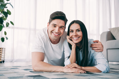 Happy couple at home in a cozy living room enjoying a relaxing day together embracing joy and loveの写真素材