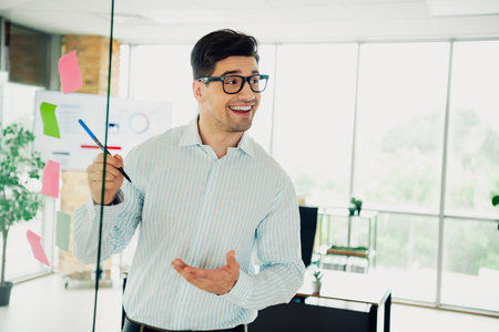 Professional businessman presenting ideas on office board in modern workplaceの写真素材