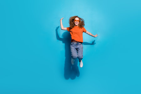 Photo of positive cheerful girl jump up move isolated blue color background