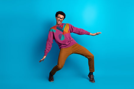 Cheerful young man posing in colorful clothing against a vibrant backdrop expressing joy and positivityの写真素材