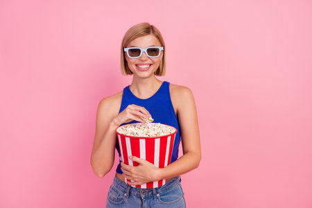 Portrait of nice young girl 3d glasses cinema popcorn wear blue top isolated on pink color backgroundの写真素材