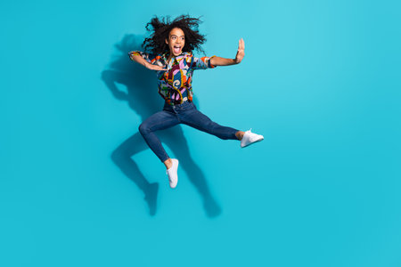 Photo of cheerful crazy girl wear stylish clothes fly air empty space isolated on blue color...