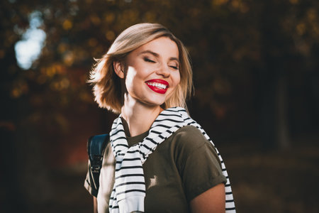 Photo of attractive young cheerful lady cheerful beaming smile wear khaki garment tied shoulders sweater having fun outside outdoorsの写真素材