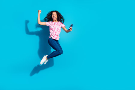 Full length photo of shiny lady dressed pink t-shirt jumping high modern device empty space isolated...