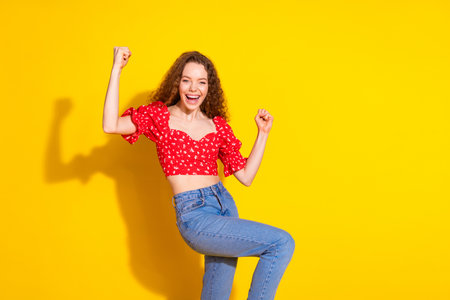 Photo portrait of lovely young lady winning raise fists dressed stylish red garment isolated on...