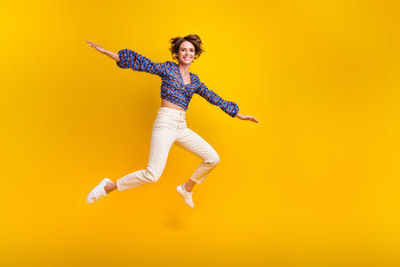 Full body length photo of young cheerful funny girl jumping flying wings arms tourist on vacation...