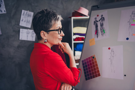 Profile portrait of dressmaker designer aged woman think whiteboard concept loft interior office studio indoorsの写真素材
