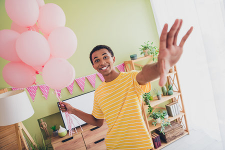 Photo of positive funny nice man preparing gift for his girlfriend celebrate valentine day living room apartmentの写真素材