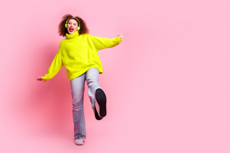 Full length photo of lovely young lady dancing headphones have fun dressed stylish yellow garment isolated on pink color backgroundの写真素材