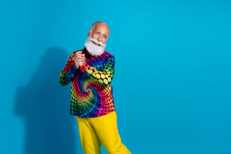 Photo of eccentric funky aged man look empty space wear shirt isolated on blue color backgroundの写真素材
