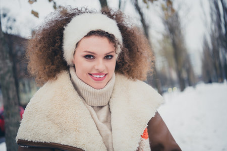 Portrait of nice young girl toothy smile good mood wear jacket walk snowy weather city street outdoorsの写真素材