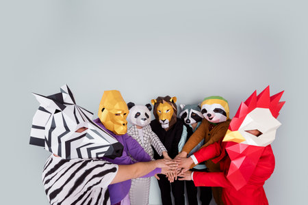 Photo of zebra gorilla raccoon lion panda sloth rooster mask people pile stack arms empty space isolated on grey color backgroundの写真素材