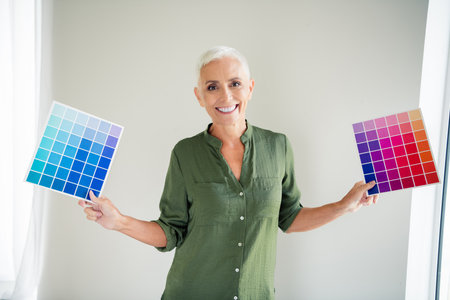 Photo of excited cheerful lady wear green shirt choosing new walls color indoors room home houseの写真素材