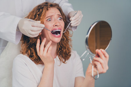 Photo of scared woman preparing for braces installation procedure professional orthodontist in dental clinicの写真素材