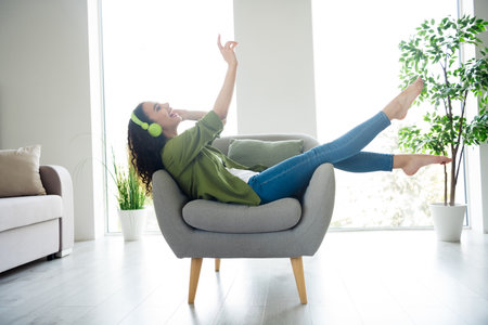 Photo of attractive cheerful girl wear khaki stylish clothes comfortable apartment flat living room daylight indoorsの写真素材