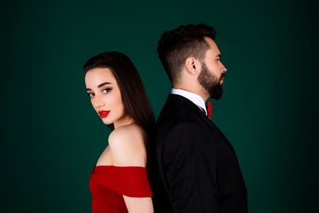 Photo portrait of classy lovely young lady gentleman couple stand backs dressed stylish fancy garment isolated on green color backgroundの写真素材