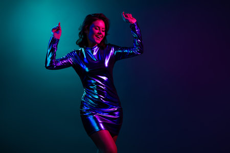 Photo portrait of pretty young girl dancing have fun good mood wear trendy discotheque vintage clothes isolated on dark backgroundの写真素材