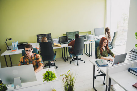 Photo of young age company colleagues diversity professional web developers sitting in comfortable open space officeの写真素材