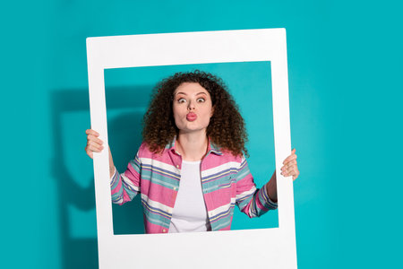 Photo of curly hair beautiful lady enjoy event entertainment pouted lips kissing holding paper...