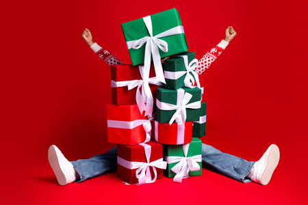 Funny holiday chaos as a girl sits with stacked gifts arms raised in joy for a merry Christmas scene
