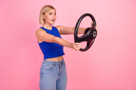 Photo of pretty young woman arms hold wheel empty space wear blue top isolated on pink color...
