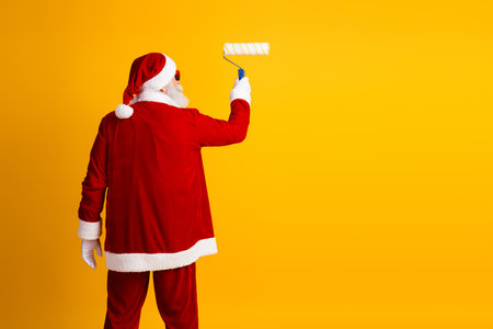 Santa Claus on a bright yellow wall with a cheerful festive mood, embodying the spirit of the holidays in a creative wayの写真素材