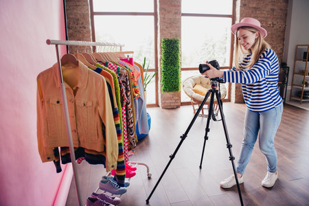 Photo of lovely girl professional blogger filming shooting clothes apparel making video content studio indoorsの写真素材