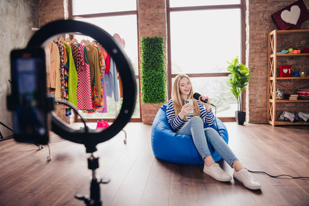 Photo of pretty lovely girl blogger singing and recording video lifestyle content live stream studio daylight indoorsの写真素材