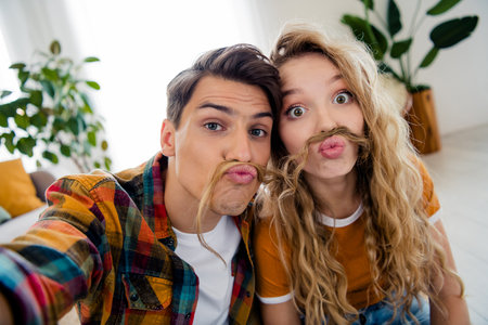 Photo of nice young couple take selfie photo have fun enjoy modern bright spring cozy interior flat indoorsの写真素材