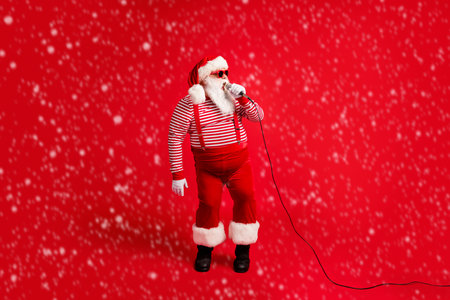 Full length body size view of handsome bearded fat overweight talented Santa vocalist star singing hit single leisure isolated bright vivid shine vibrant red color backgroundの写真素材