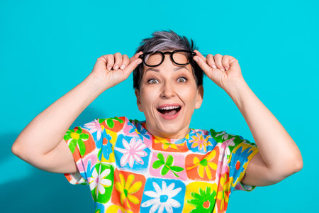 Portrait of aged lady hands touch glasses wear t-shirt isolated on turquoise color background