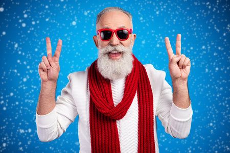 Photo of funky age gentleman wear white red sweater red eyewear smiling showing v-sign isolated blue color backgroundの写真素材