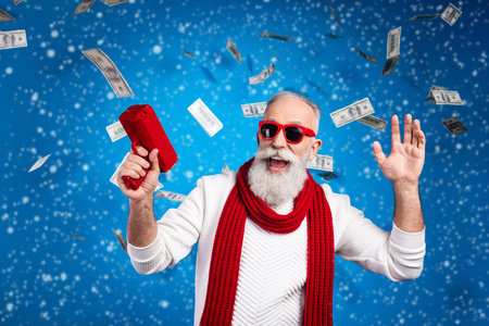 Photo of mature man dressed white pullover red glasses showing money profit isolated blue color backgroundの写真素材