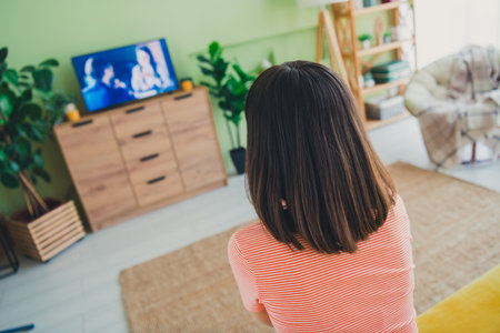 Charming young woman enjoying a relaxing weekend at home, seated comfortably in her stylish striped t-shirtの写真素材