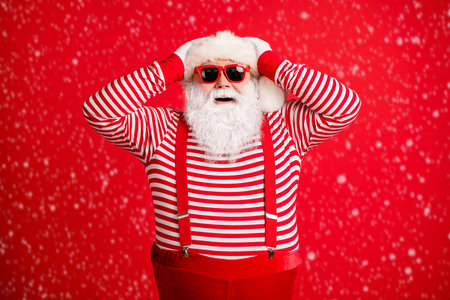 Portrait of his he nice handsome attractive cheerful cheery amazed grey-haired Santa having fun festal party occasion isolated over bright vivid shine vibrant red color backgroundの写真素材